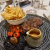 Steak and chips on a grey plate