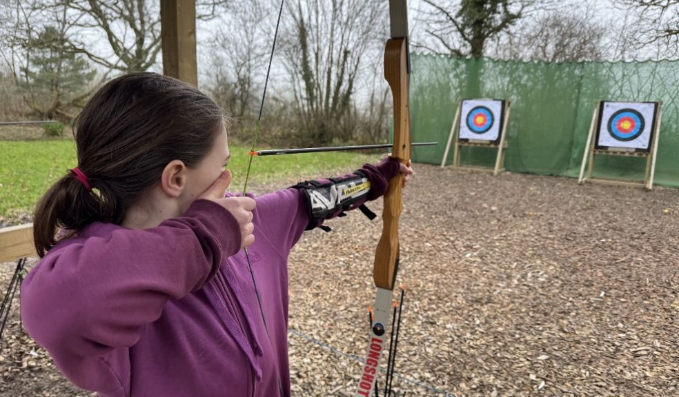 A young girl prepares to shoot an arrow at The Mole Resort