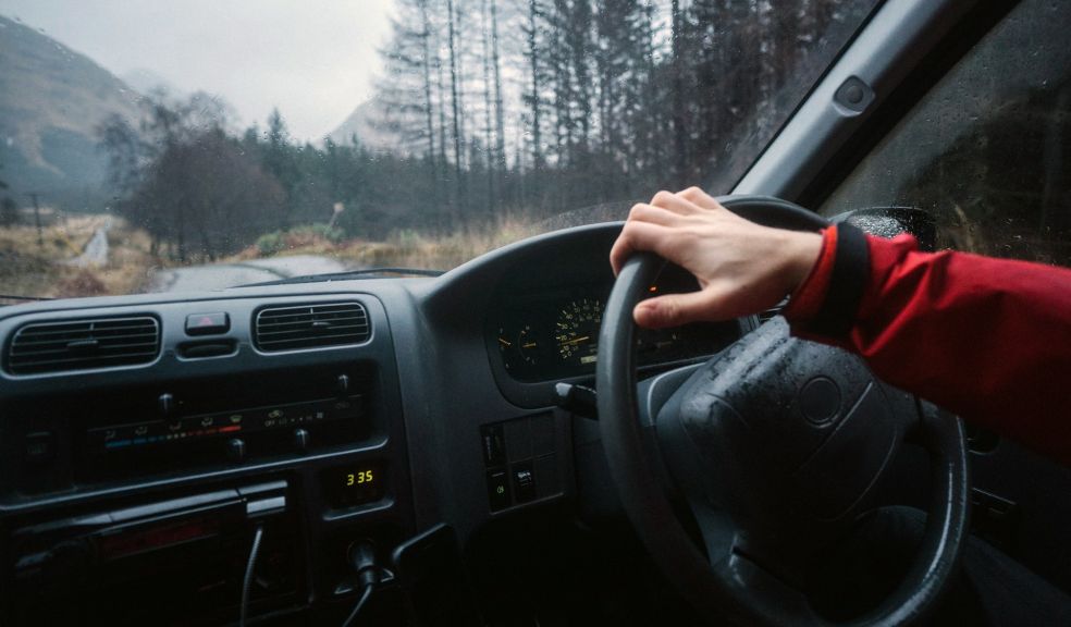 man driving a car through Scotland