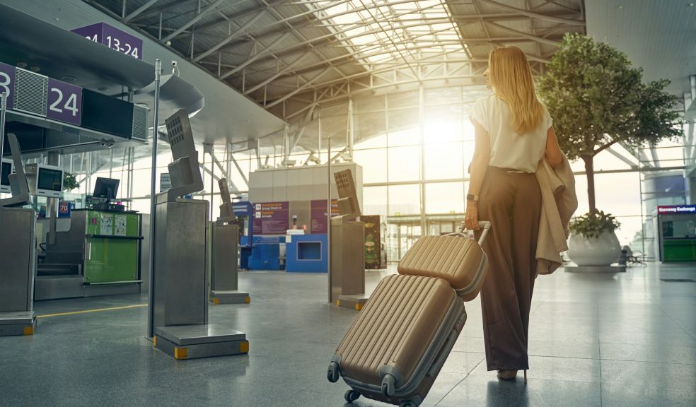 female person carrying her luggage in an airport heading to the gate to board an aeroplane