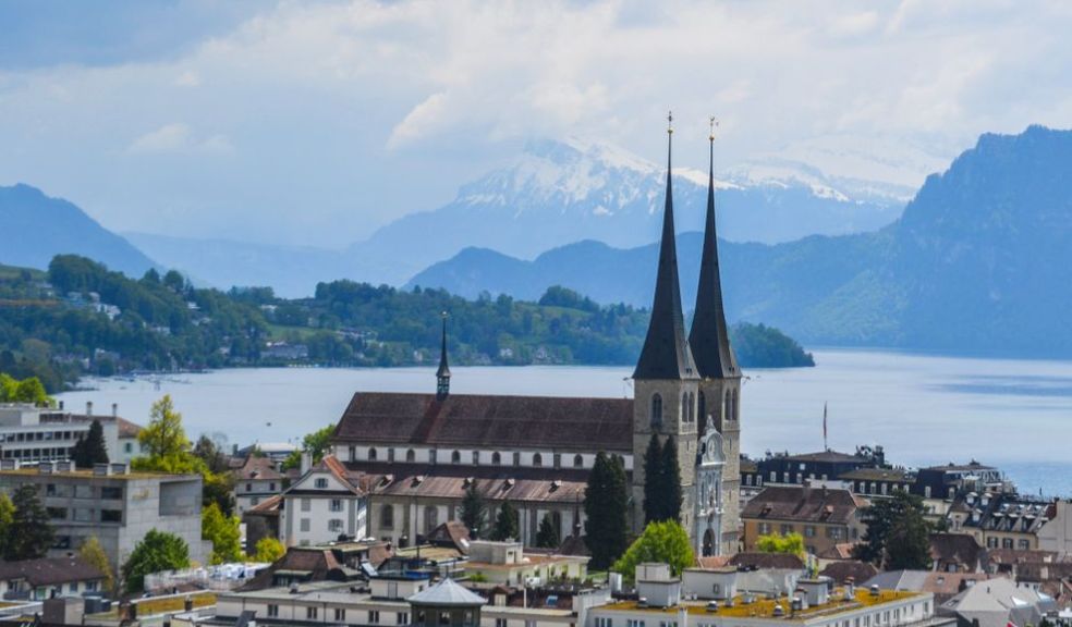Scenic view of Lucerne, Switzerland featuring a historic church and beautiful lake backdrop.