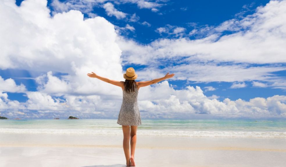 woman happy beach holiday amber list vaccinated brits travel