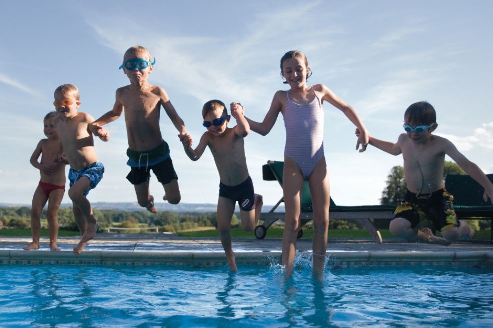 picture of children jumping into an outdoor pool
