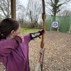 A young girl prepares to shoot an arrow at The Mole Resort