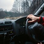 man driving a car through Scotland