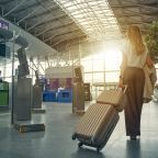 female person carrying her luggage in an airport heading to the gate to board an aeroplane