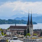 Scenic view of Lucerne, Switzerland featuring a historic church and beautiful lake backdrop.