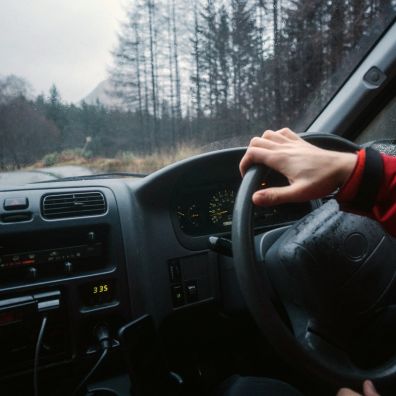 man driving a car through Scotland
