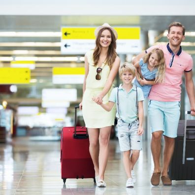family walking through airport with luggage