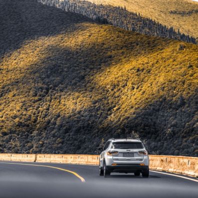 car driving on an open road through mountains
