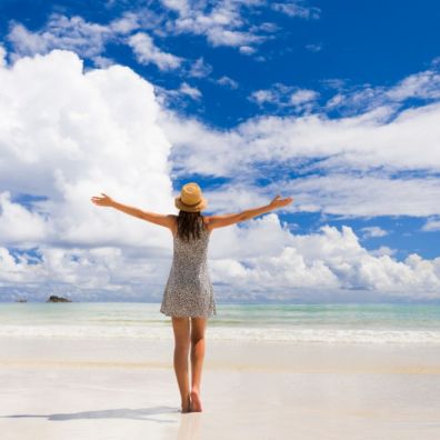woman happy beach holiday amber list vaccinated brits travel